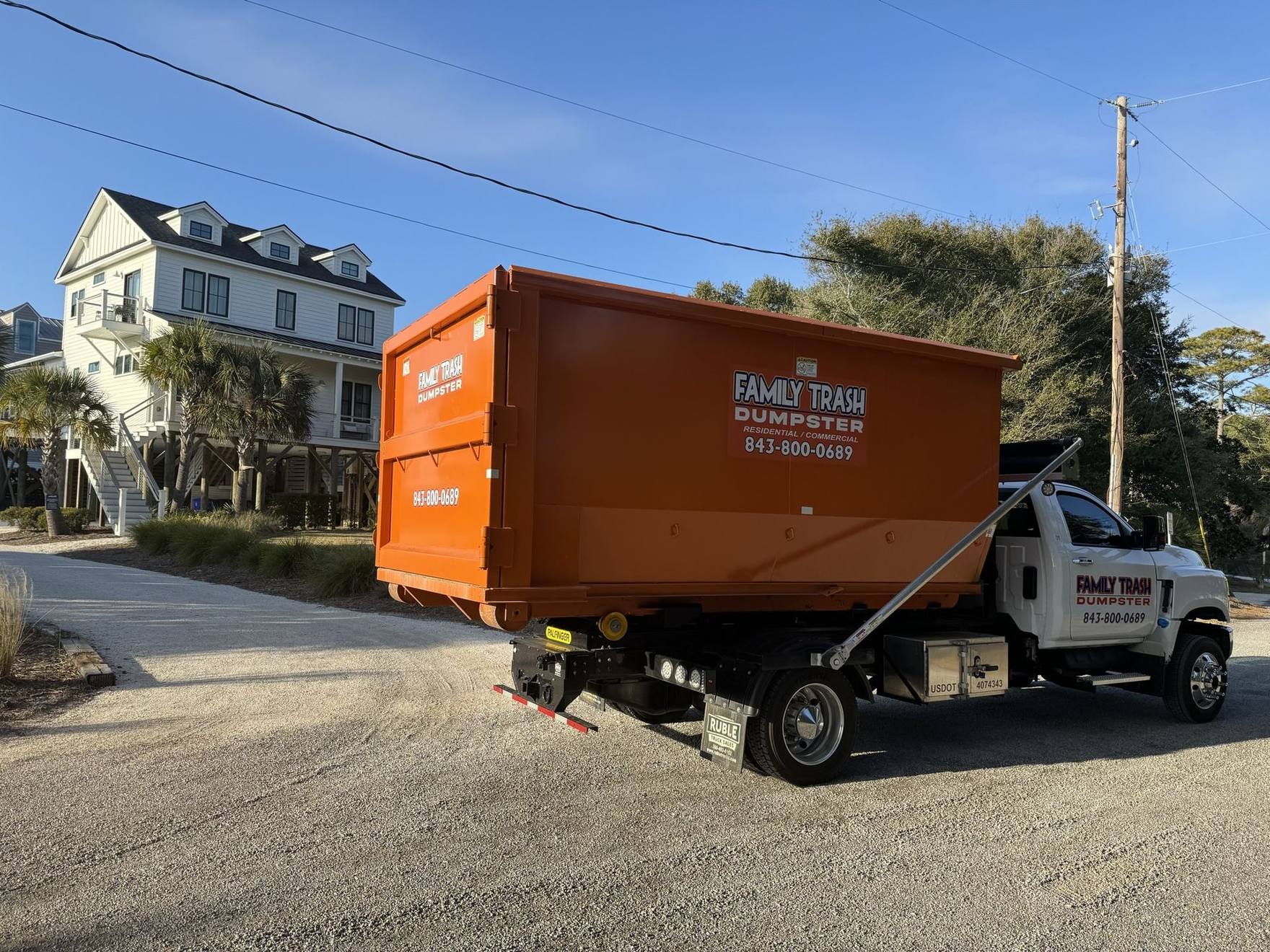 Family Trash truck delivering a dumpster in Charleston